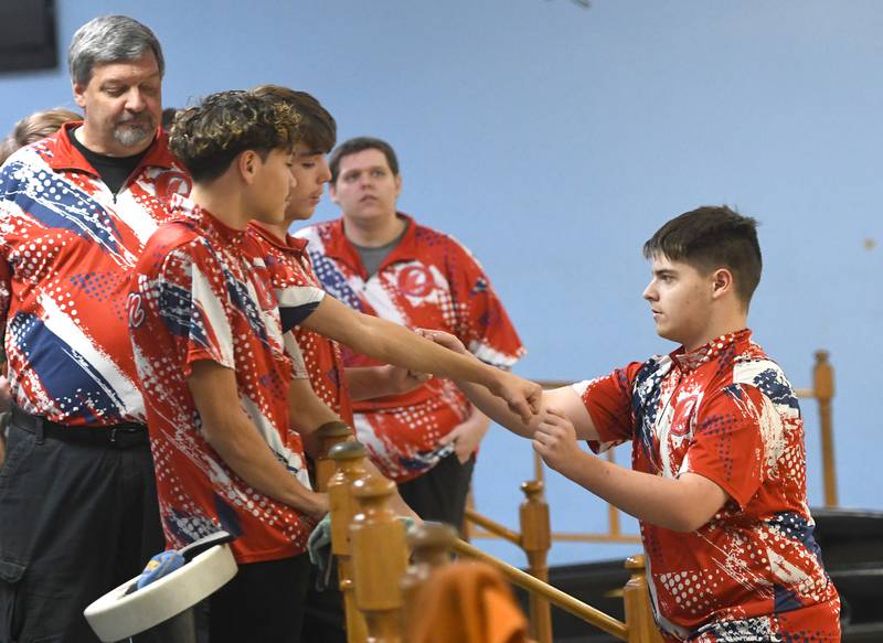 Oregon's Rylann Delehanty (right) celebrates with his teammates after throwing a strike during a match with Harvard at Town & Country Lanes in Mt. Morris on Friday, Dec. 19, 2025.