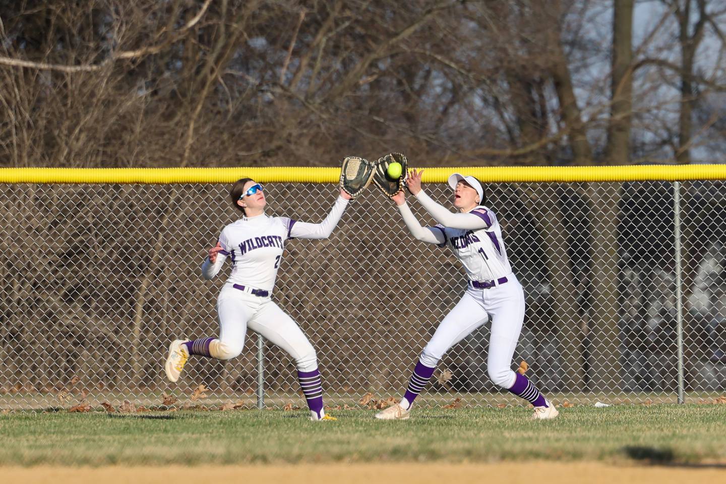Wilmington's Molly Southall, right, makes a catch in center field as teammate Sami Liaromatis also runs in during the Wildcats' 22-5 victory over Central on Wednesday, March 26, 2025.