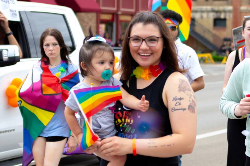 Parader holds baby with pride flag on Saturday, June 8, 2024 at Jordan Block Park in Ottawa.