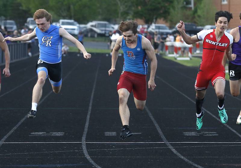 Burlington Central’s Nolan Milas, Dundee-Crown’s Henry Kennedy, and Huntley’s Evan Gronewold, lean for the finish line in the 100 meter dash during Fox Valley Conference boys track and field meet Friday, May 13, 2022, at Crystal Lake Central High School.