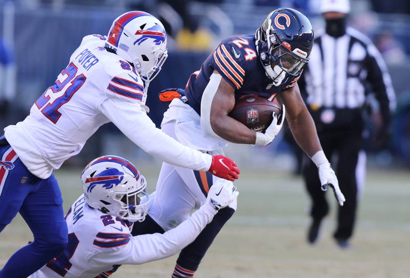 Chicago Bears running back Khalil Herbert tries to pull away from Buffalo Bills cornerback Kaiir Elam and safety Jordan Poyer during their game Sunday, Dec. 24, 2022, at Soldier Field in Chicago.