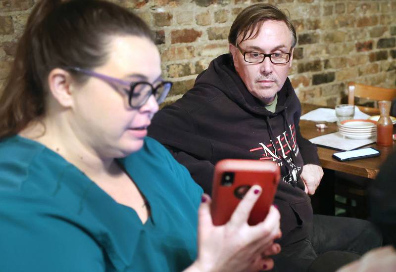 Scott McAdams, running to retain his seat on the city council in DeKalb’s 5th Ward, checks results on a friends phone Tuesday, April 4, 2023, during an election night watch party at Rosita's Mexican Restaurant in DeKalb.