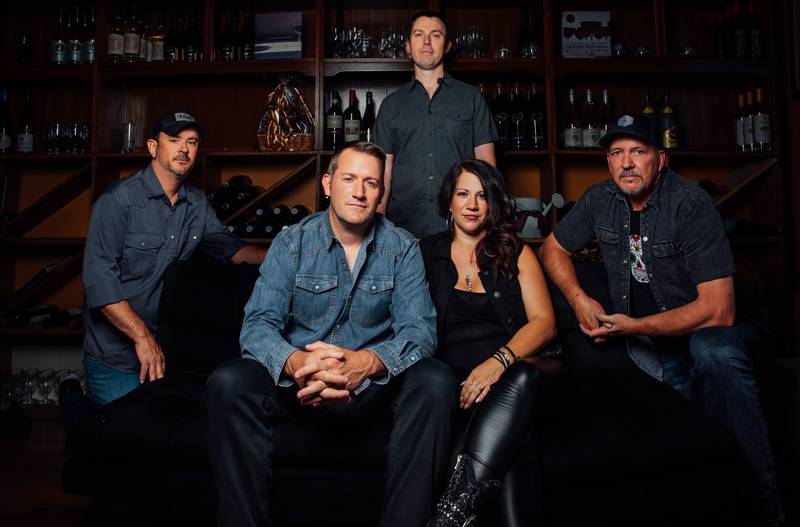 Laura Patricia, who helms The Studio in Lockport and is herself a musician and vocalist, is pictured in its wine room with fellow band members of The Simple Remedy. Band from left to right: Michael Pentz, Edward Ryan, Andy Wilmoth, Laura Patricia, Mike Smith