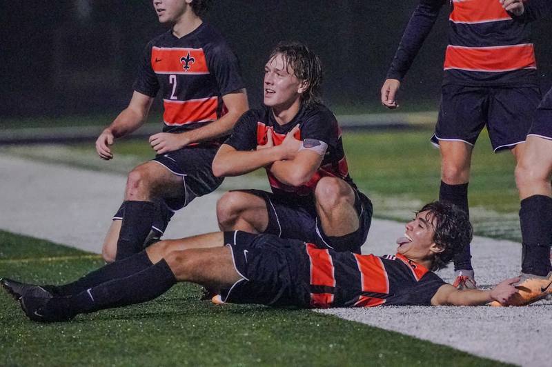 St. Charles East's Griffin Counts (middle) and Giuseppe Avendano (10) pose for the crowd after scoring a goal against West Chicago during a class 3A sectional semifinal soccer match at West Chicago High School on Wednesday, Oct. 25, 2023.