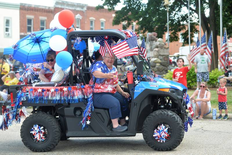 A rider in the Just 4 Fun Ice Cream entry tosses candy to the crowd from a decorated ATV during the 2023 Let Freedom Ring parade on Tuesday,  July 4.