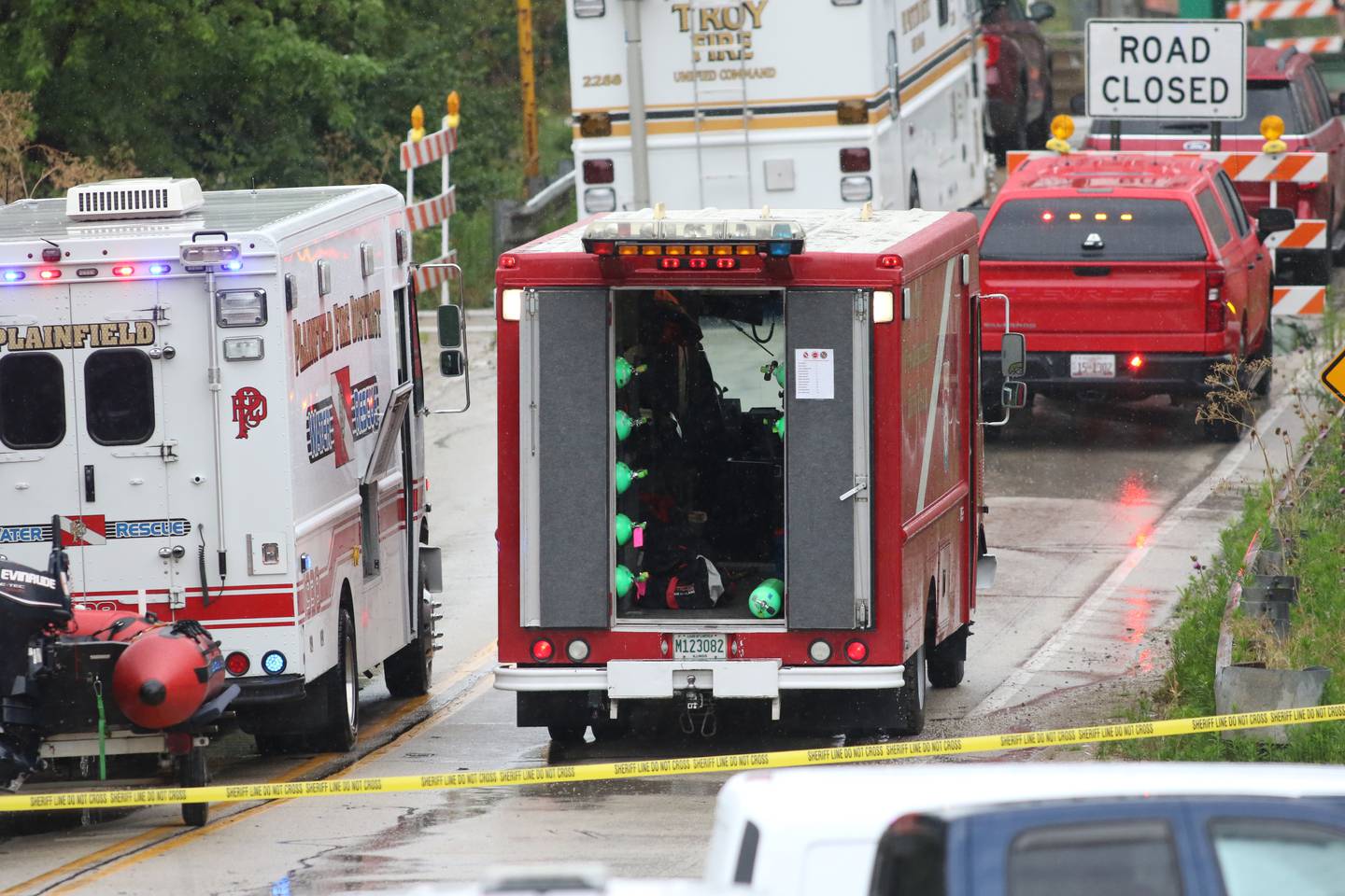 Emergency vehicles line the roadway by the bridge over the Des Plaines River at the Brandon Road Lock and Dam in Rockdale on Tuesday, July 9, 2024.  Crews from several Will County fire and police departments were there searching the area and river for a vehicle that went into the river reportedly on July 2, 2024.or pictures