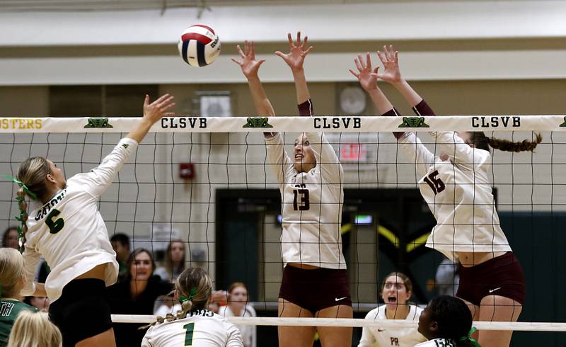 Crystal Lake South's Bobbi Wire tries to hit the ball through the block of Prairie Ridge's Abigail Smith (center) and Adeline Grider during the IHSA Class 3A Crystal Lake South Sectional final volleyball match on Thursday, Nov. 7, 2024, at Crystal Lake South High School.