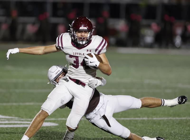 Loyola's Drew MacPherson (34) breaks free from the Mt. Carmel defense during the varsity football game between Loyola Academy and Mt. Carmel high school on Friday, Oct. 25, 2024 in Chicago.