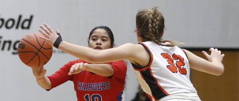Dundee-Crown’s Theriz Mercado passes the ball as she is guarded by McHenry's Lucy Jones during a Fox Valley Conference girls basketball game on Tuesday, Dec. 12, 2023, at McHenry High School.