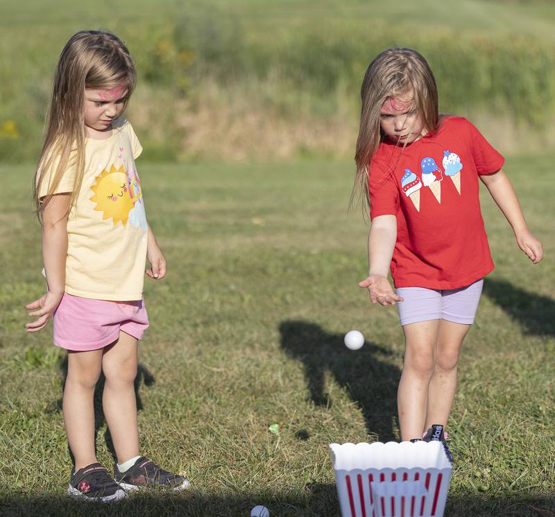 Twins Claire (left) and Chloe Havenar, 5, try their luck at Dixon PTO’s “Party in the Playground” Thursday, Aug. 29, 2024, at Wooden Wonderland.
