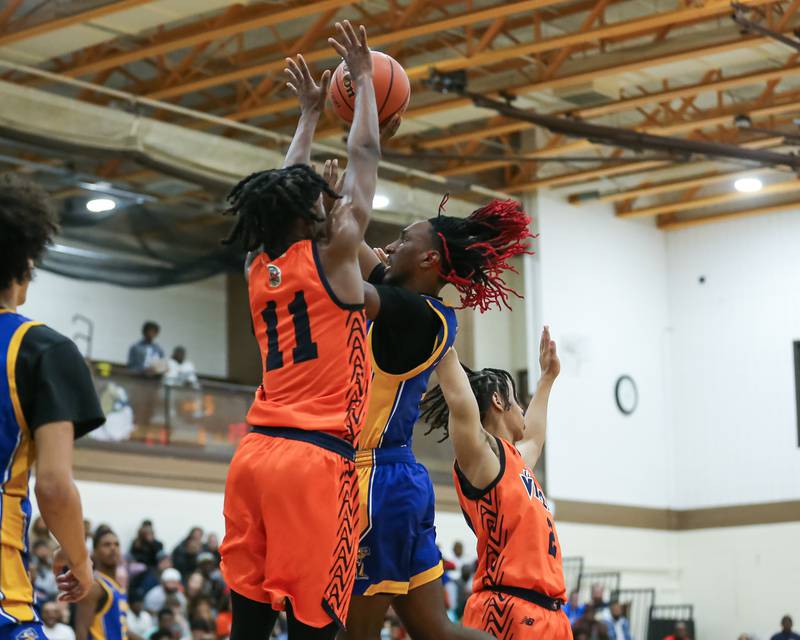 Joliet Central's JaMarcho Holman (1) goes up against Romeoville's TJ Lee (11) at the basket in the WJOL Tournament Championship game. Nov 25, 2023.