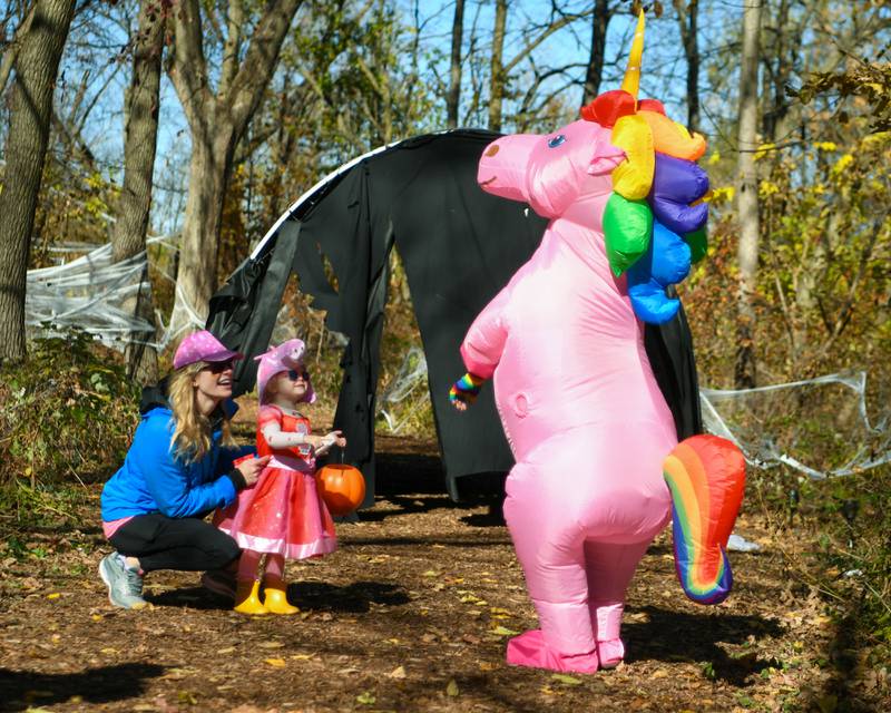 Kerri Kostal along with daughter Annabelle Kostal, 2, of Glen Ellyn enjoy their conversation with a unicorn on Saturday Oct. 26, 2024, after receiving some candy during the Boo Bash event held at Ackerman Park in Glen Ellyn.