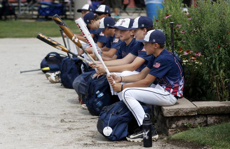 Members to the Cay Trojans baseball team play with their bates as the wait for the game to begin during the opening round of the Under 13 McHenry County Youth Sports Association’s Summer International Championship baseball tournament on Friday, July 11, 2025, at the Mickey Sund Baseball Complex in Crystal Lake's Lippold Park.