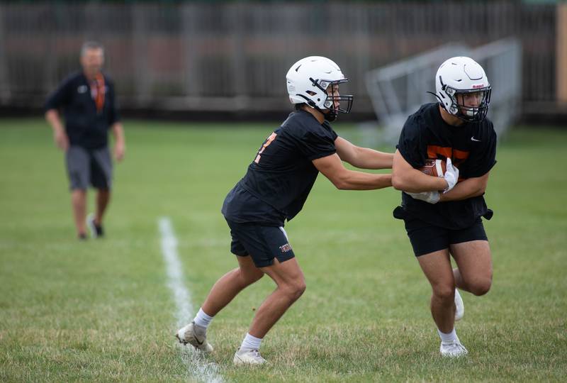 Quarterback Lane Robinson hands off the ball during practice at St. Charles East on Monday, Aug. 8, 2022.