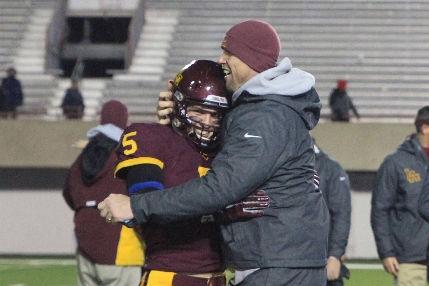 Beau Desherow (right) celebrates with son Robert J. “Bobby” Desherow ’16 after Loyola defeated Marist 41-0 to clinch the 2015 IHSA Class 8A state championship, the second in school history. At the time, Desherow served as varsity defensive line coach. Photo provided by Loyola Academy.