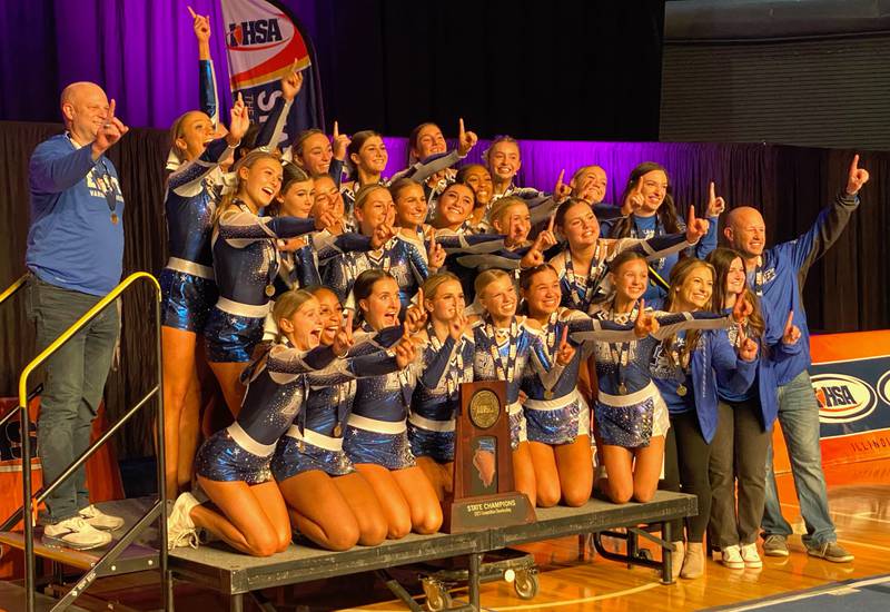 The IHSA state champion Lincoln-Way East competitive cheer team, pictured here accepting their first-place plaque, includes: in front (left to right) - Allie Collins, London Joy, Marissa Mangin, Emily LaValle, Delaney Drogemuller, Sofia Aguilar, Fiona Hilbert, coach Jen Ryan, coach Lauren Williams, coach Jayson Polad; in middle - Courtney Marneris, Francesca Totosz, Kelly Hannigan, Mairi Lehan, Lauren Ristich, Francesca Flaris, Kayla Reasanova, Isabella Talowski, Rose Walenga, Gwen Drechsel, coach Maddy Enright; in back - athletic director Mark Vander Kooi, Kaitlyn Regnier, Lauren Vander Kooi, Rian Willingham, Payten Dircks, Savannah Stolarek, Gianna Bianchini and Olivia Boswell.