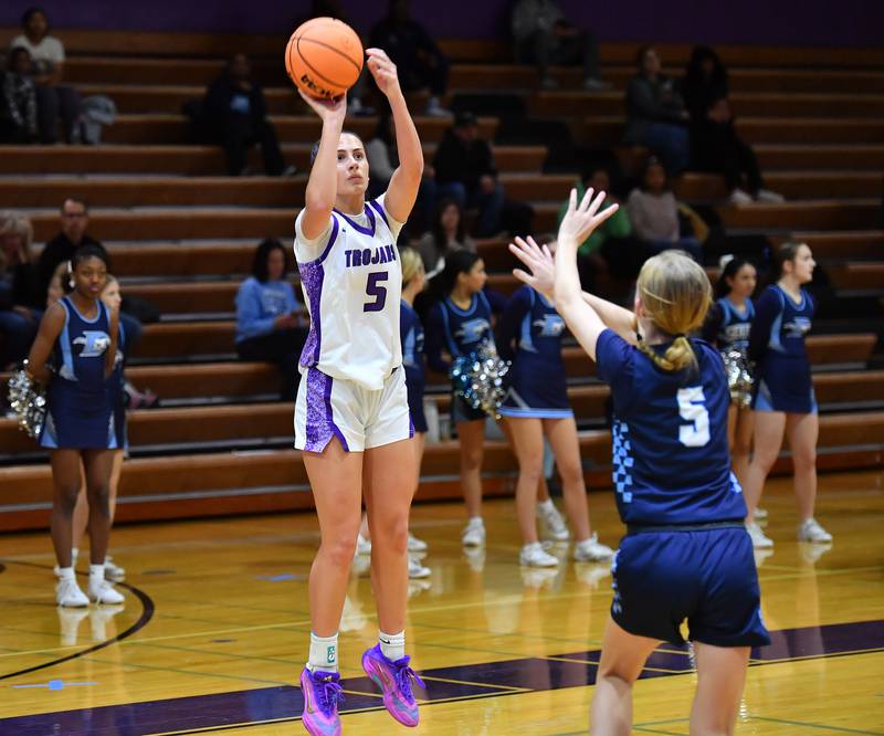 Downers Grove North’s Campbell Thulin shoots for three points as Downers Grove South’s Molly Mihalik defends during a game on December 20, 2025 at Downers Grove North High School in Downers Grove.