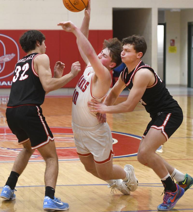 Oregon's Keaton Salsbury draws contact as he drives between Forreston's Kendall Erdmann (right) and Johnathan Milnes during a Tuesday, Feb. 17, 2026 game at the Blackhawk Center in Oregon.