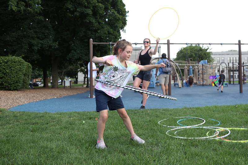 Leah Novak, 8 years-old from Mokena, uses one of the hula-hoops that Emily Bandera, background, provided for the evening concert at Preservation Park. The Upper Bluff Historic District hosted Porch & Park Music Fest featuring a variety of musical artist at five different locations. Saturday, July 30, 2022 in Joliet.