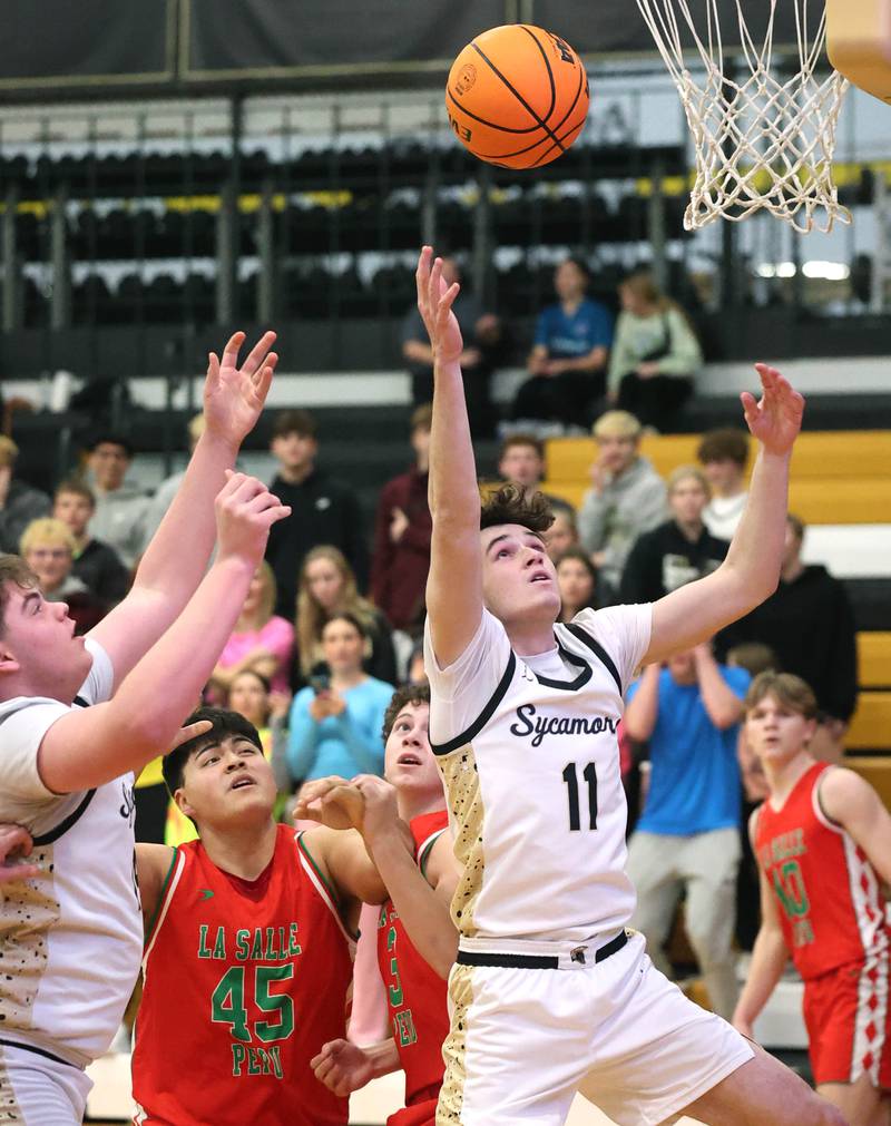 Sycamore's Jake Shipley grabs a rebound in front of La Salle-Peru's Andy Medina during their game Tuesday, Feb. 4, 2025, at Sycamore High School.