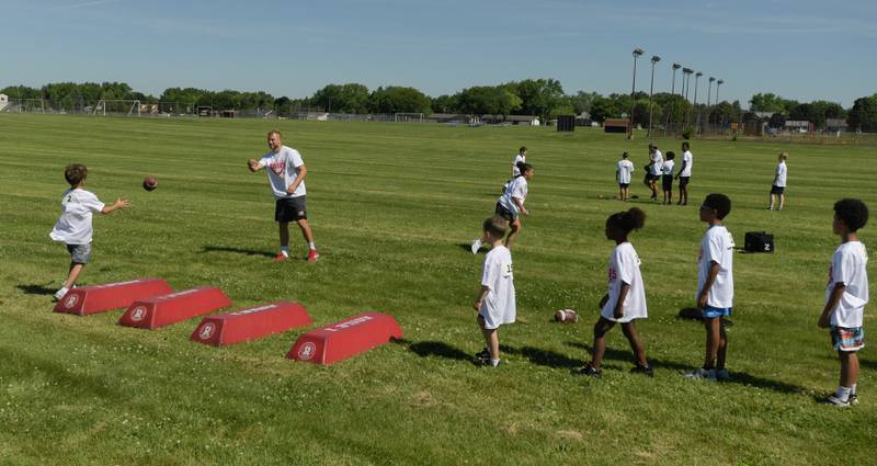 NIU’s Cole Tucker works with youth during the inaugural Legends of the 60115 Football Camp with in DeKalb on Sunday, June 26, 2022.