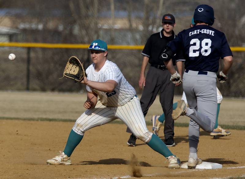 Woodstock North's AJ Cohen waits for the throw as Cary-Grove's Brock Iverson runs through first base during a nonconference baseball game on Monday, March 30, 2026, at Woodstock North High School.