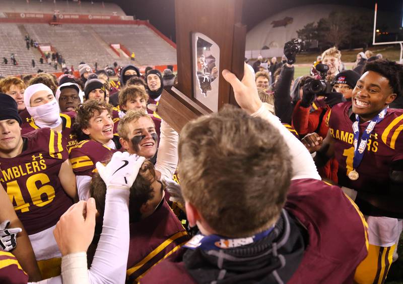 Loyola Academy player celebrate with the trophy after their Class 8A state championship game win over York Saturday, Nov. 30, 2024, in Hancock Stadium at Illinois State University in Normal.