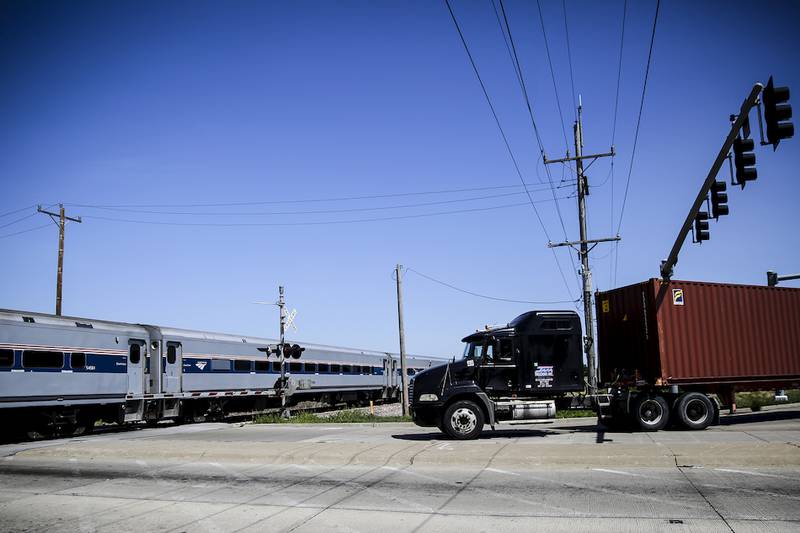 A semitrailer waits for a train to pass as it turns onto Walter Strong Drive off Route 53 in Elwood in August.
