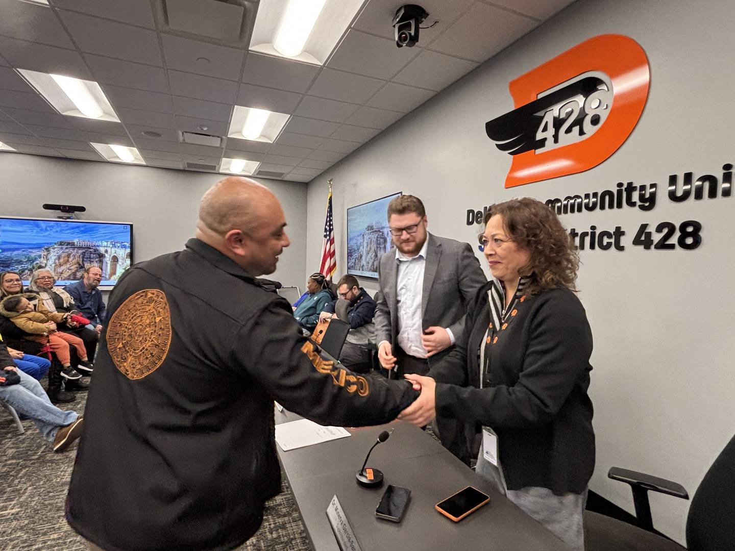 Billy Hueramo shakes hands with Minerva Garcia-Sanchez at a Jan. 5, 2026, meeting of the DeKalb School District 428 Board of Education.