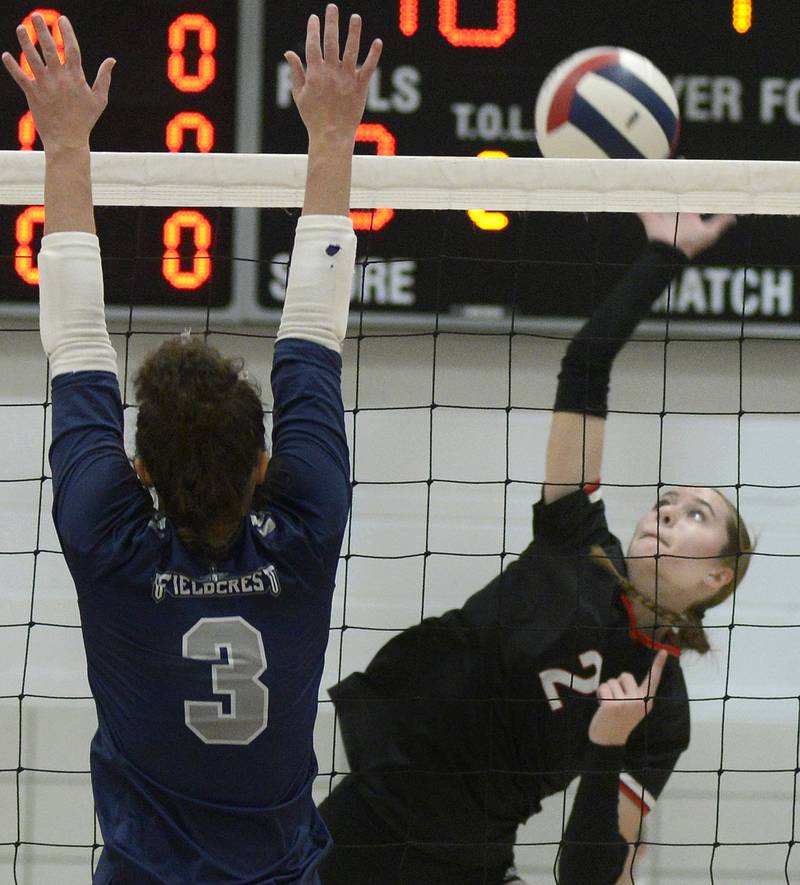 Woodland’s Addy Ewing tips the ball as Fieldcrest’s Macy Gochanour rises to block Tuesday, Oct. 28, 2025, at Woodland School in rural Streator.