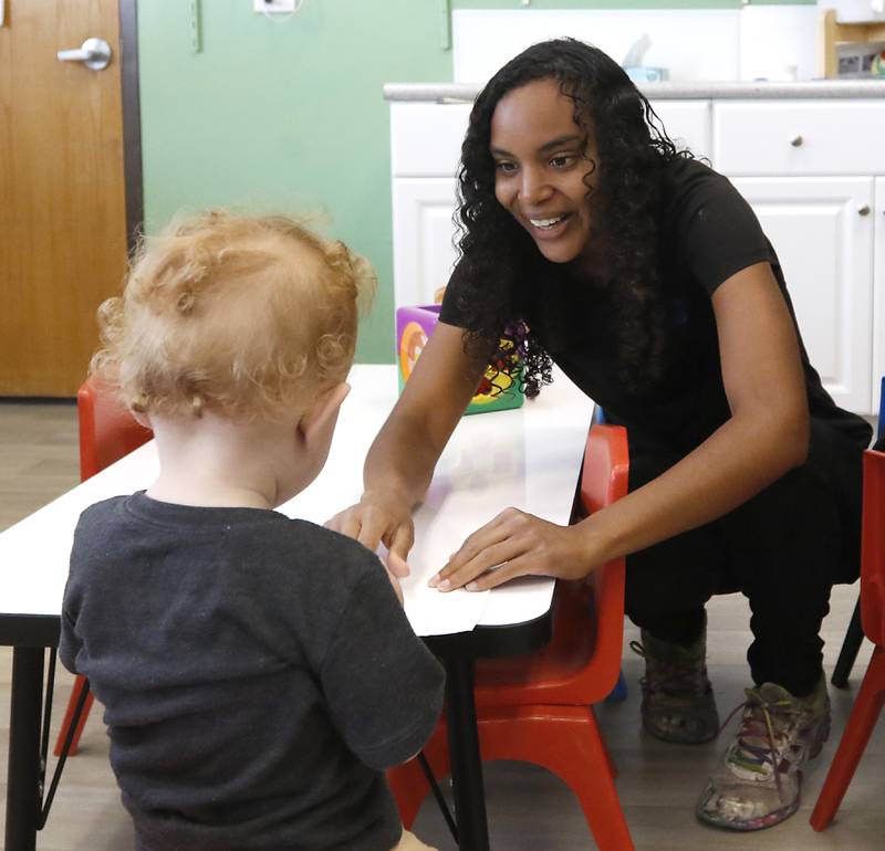 Teacher Marcye Meisinger interacts with a with a student as he draws a picture with markers Thursday, July 28, 2022, at the Friendship House, 100 South Main Street, in Crystal Lake. Childcare centers are struggling to find enough teachers to maintain operations.