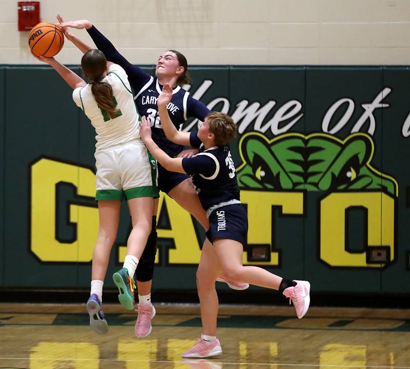 Crystal Lake South's Gaby Dzik (left) has her shot blocked by the defense of Cary-Grove's Olivia Leuze (center) and Jayden Sopata-Rahn (right) during a Fox Valley Conference girls basketball game on Friday, Jan. 23, 2026, at Crystal Lake South High School.
