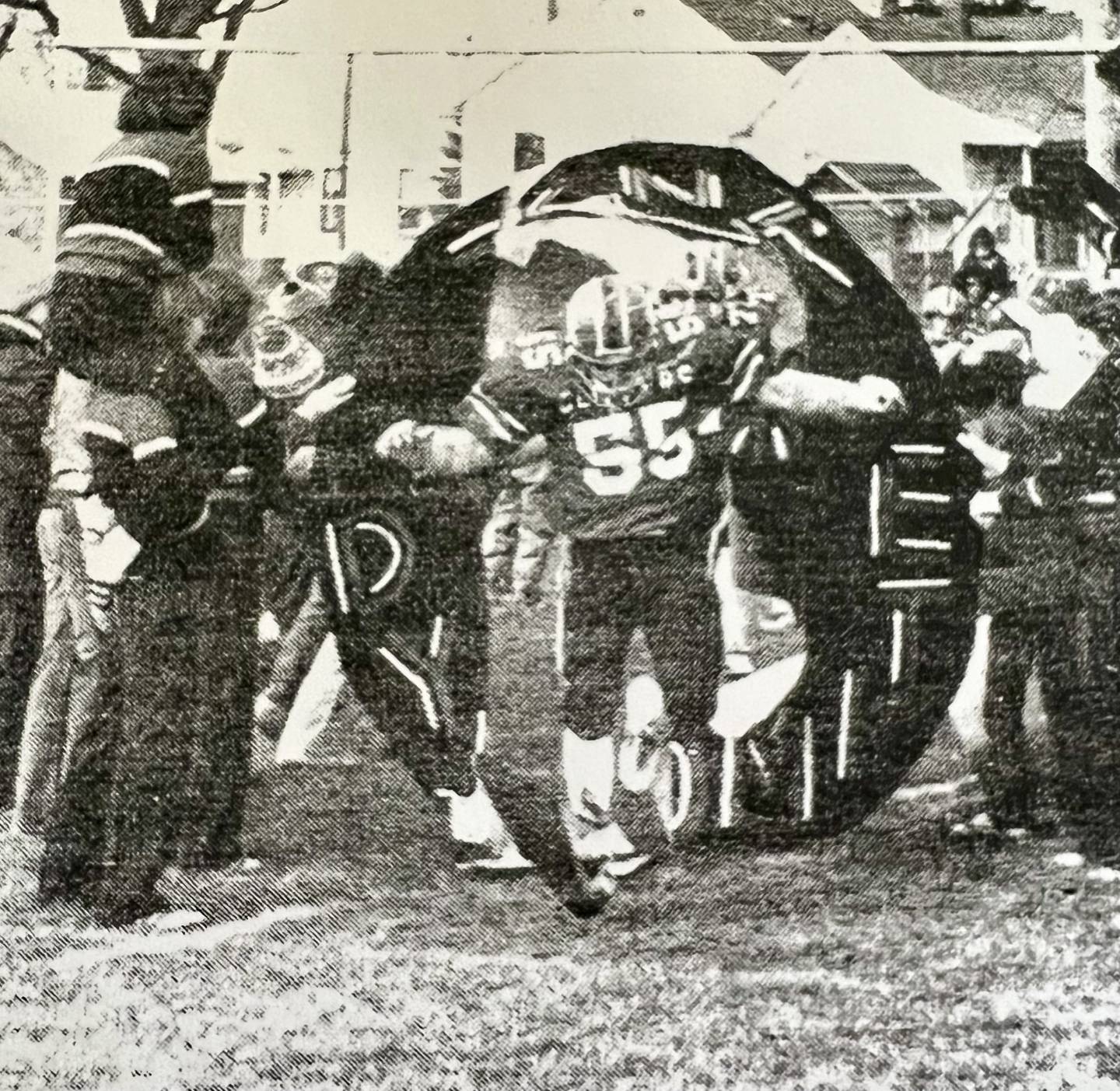 Dennis McCoy breaks the banner for the Amboy football team during their 1979 playoff run. He was killed in an accident on Oct. 21. The Clippers wore his No. 55 on their helmets during Saturday's playoff game.