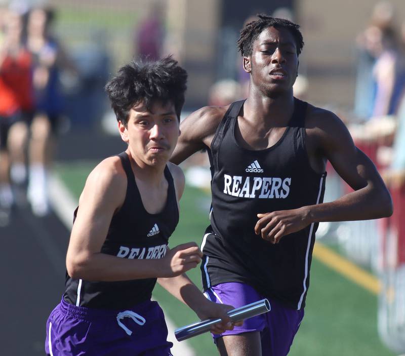 Plano’s Trevion Gilford, right, hands off to Alejandro Delgado in the 3200-meter relay in KRC Conference Track Meet action at Richmond-Burton High School in Richmond on Tuesday, May 13, 2025.