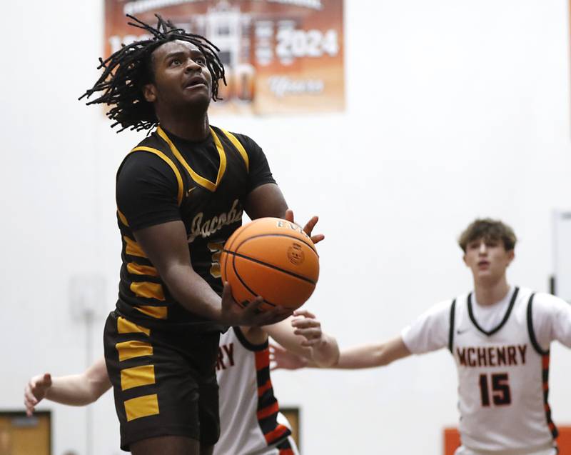 Jacobs' Emaan Thomas shoots the ball in front of McHenry's Blake Renfro during an IHSA Class 4A McHenry Regional basketball game on Wednesday, Feb. 26, 2025, at McHenry High School.