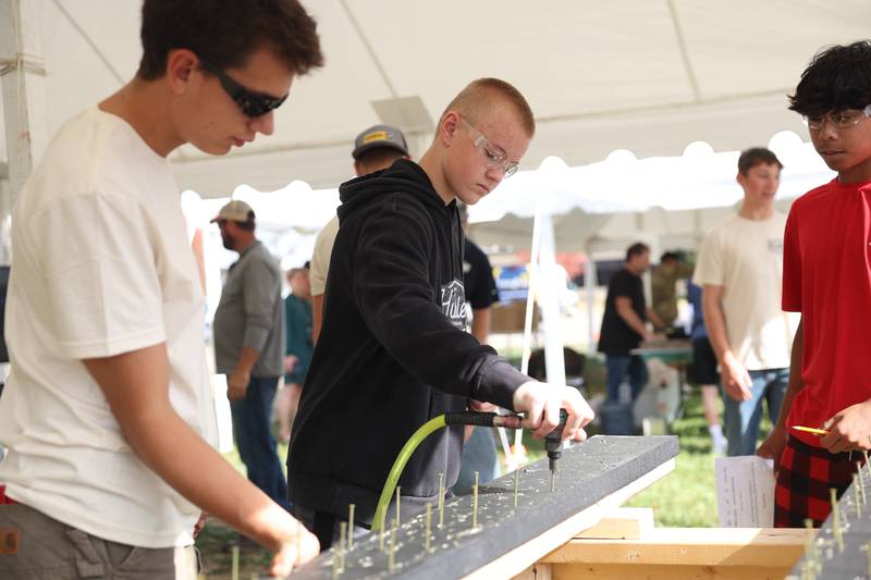 A student uses an impact nailer at one of the trade skills tents at the Grundy Area Vocational Center 8th grade Career Fair at Morris High School on Tuesday, Oct. 29, 2024 in Morris