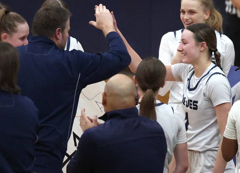 Oswego East's Aubrey Lamberti (right) is congratulated by her coach after scoring her 1,000 career point during their game against Yorkville Tuesday, Feb. 11, 2025, at Oswego East High School.
