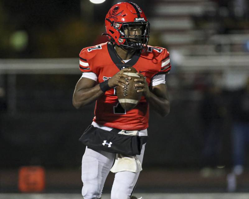 Bolingbrook's Tyson Ward (7) looks down field after rolling out during football game between Yorkville at Bolingbrook Friday, Oct 24, 2025 in Bolingbrook.