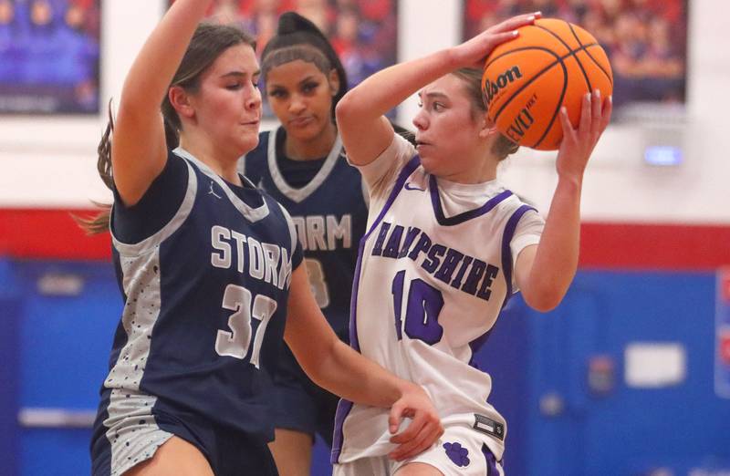 Hampshire’s Peyton McCarthy, right, looks for an option as South Elgin’s Kylie Germano Finn, left, defends in varsity girls basketball Komaromy Classic tournament  action on Monday, Dec. 29, 2025, at Dundee-Crown High School in Carpentersville.