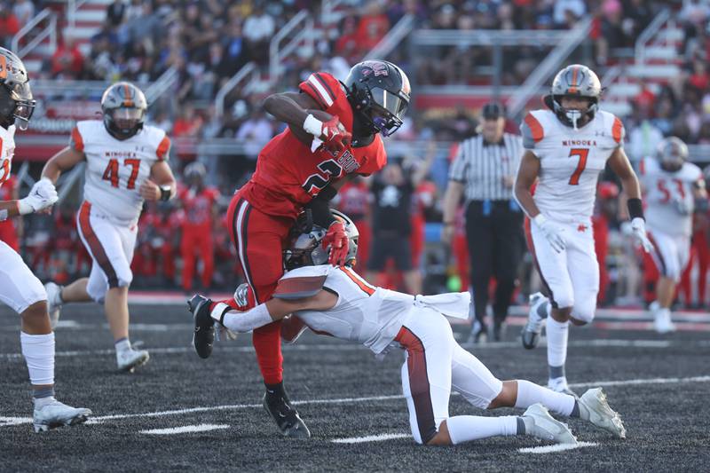 Bolingbrook’s Kyan Berry-Johnson takes a hit but not before gaining the first down against Minooka. Friday, Aug. 26, 2022, in Bolingbrook.