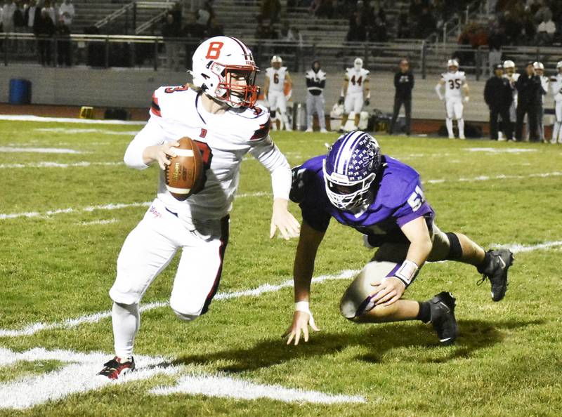 Benet Academy quarterback Ryan Kubacki evades Rochelle defensive lineman Colton Czekala during Friday’s second-round playoff matchup against the Hubs in Rochelle.