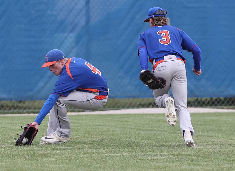 Genoa-Kingston's Ethan Wilnau fields a grounder in center field as Brody Engel runs by during their game against Rockford Lutheran Tuesday, May 2, 2023, at Genoa-Kingston High School.