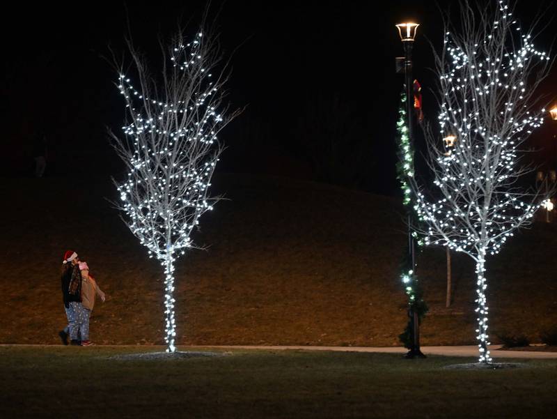Dylan Arthur, of Bradley, and Hope Tapp, of Bourbonnais, enjoy a stroll along one of the newly decorated walkways on Thursday at The Grove in Bourbonnais on during the inaugural Christmas tree lighting.