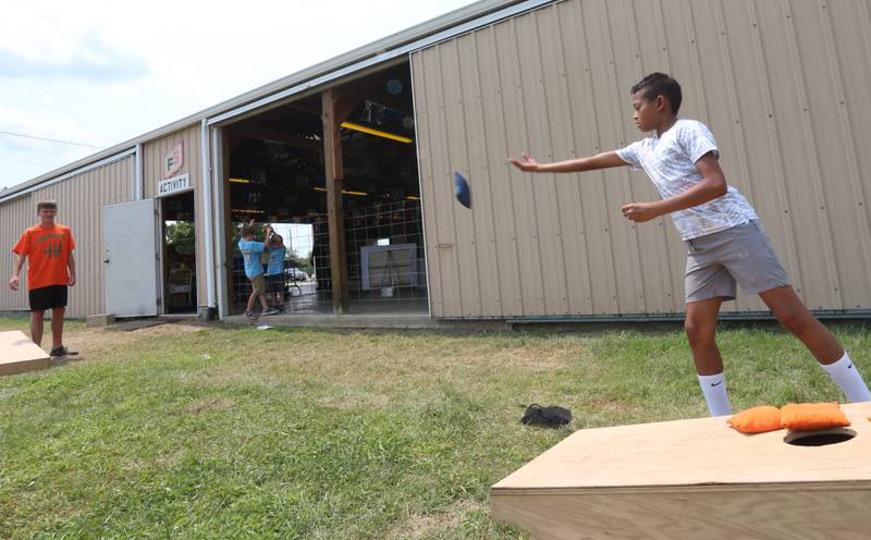 Reece Conroy of Minonk, plays cornhole with his friend Brody Lutz of Minonk, during the Marshall-Putnam 4-H Fair on Tuesday, July 23, 2024 at the Marshall-Putnam Fairgrounds in Henry.