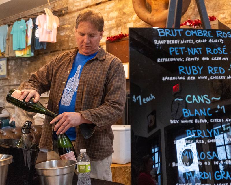 Jim Blough pours wine into bottle at Bruce & Ollie’s during the wine walk on Feb. 14, 2026 on Mill Street in Utica.
