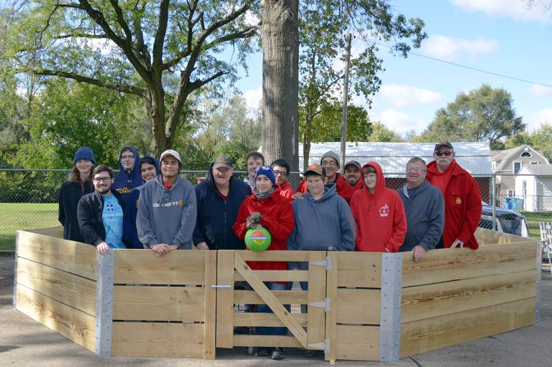 Gab Buelvas, 17, of Dixon, (center, blue hat), poses with the group of volunteers inside the completed gaga ball pit he led them in building for Vaile Park on Saturday, Oct. 7, 2023. The gaga ball pit was Buelvas' Eagle Scout project.