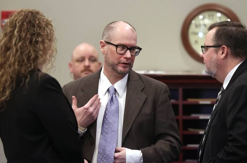 Jonathan Hurst (center) talks to his attorneys Emma Franklin and Chip Criswell Thursday, Jan. 23, 2025, during his trial at the DeKalb County Courthouse in Sycamore. Hurst is charged in the 2016 slayings of Sycamore elderly mother and son Patricia and Robert Wilson.