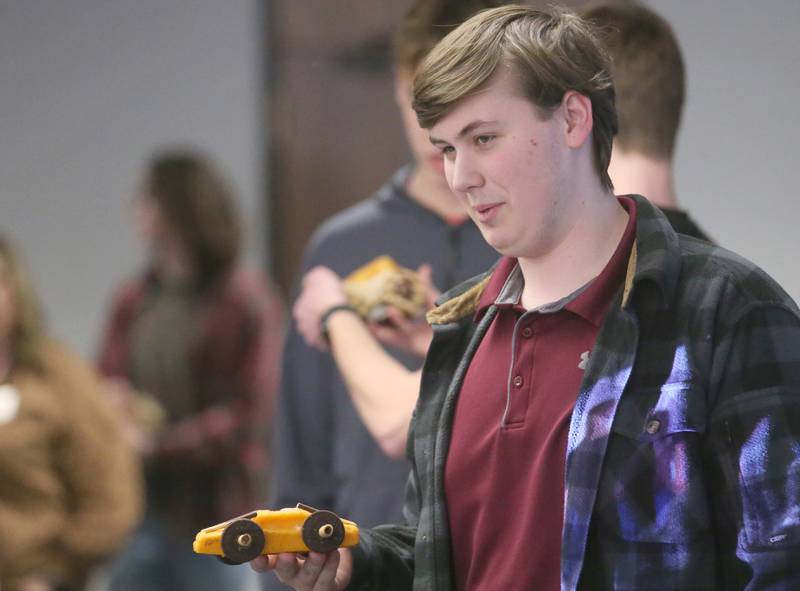 Keean Atkins of La Salle-Peru Township High School, holds his car made out of cheese before racing it during the 29th annual Edible Car Contest on Wednesday, Feb. 26, 2025 in the cafeteria at Illinois Valley Community College.