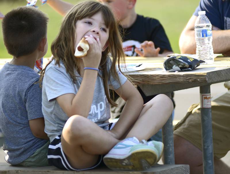 Mackenzie Roetker enjoys a hot dog Tuesday evening at Peck Park in Ottawa during National Night Out.