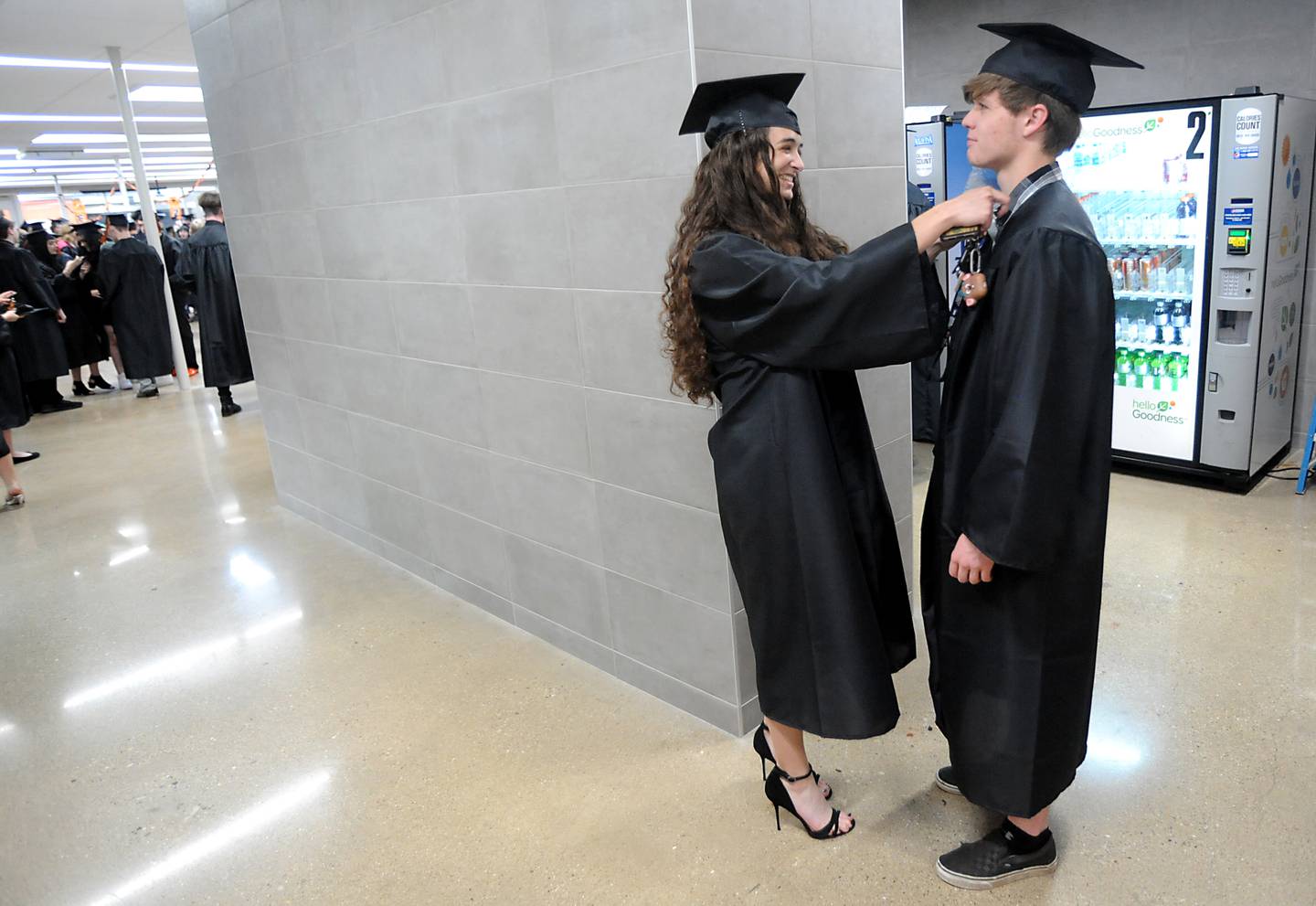 Guinevere Popovich helps straight up Logan Fuhler’s gown Saturday, May 14, 2022, ahead of the graduation ceremony at Crystal Lake Central High School.